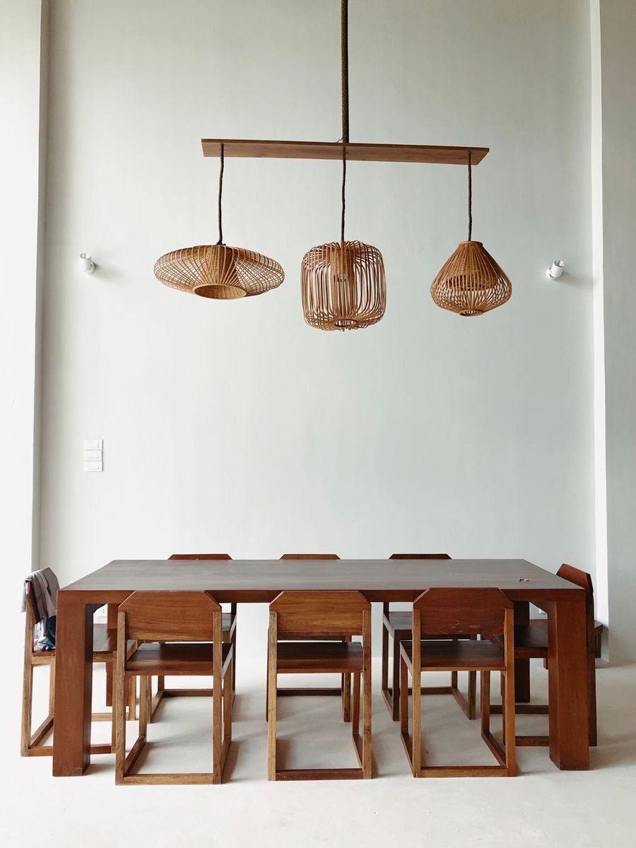 Dining room with a solid wood table and matching chairs beneath a pair of rustic pendant lamps hung low over the table