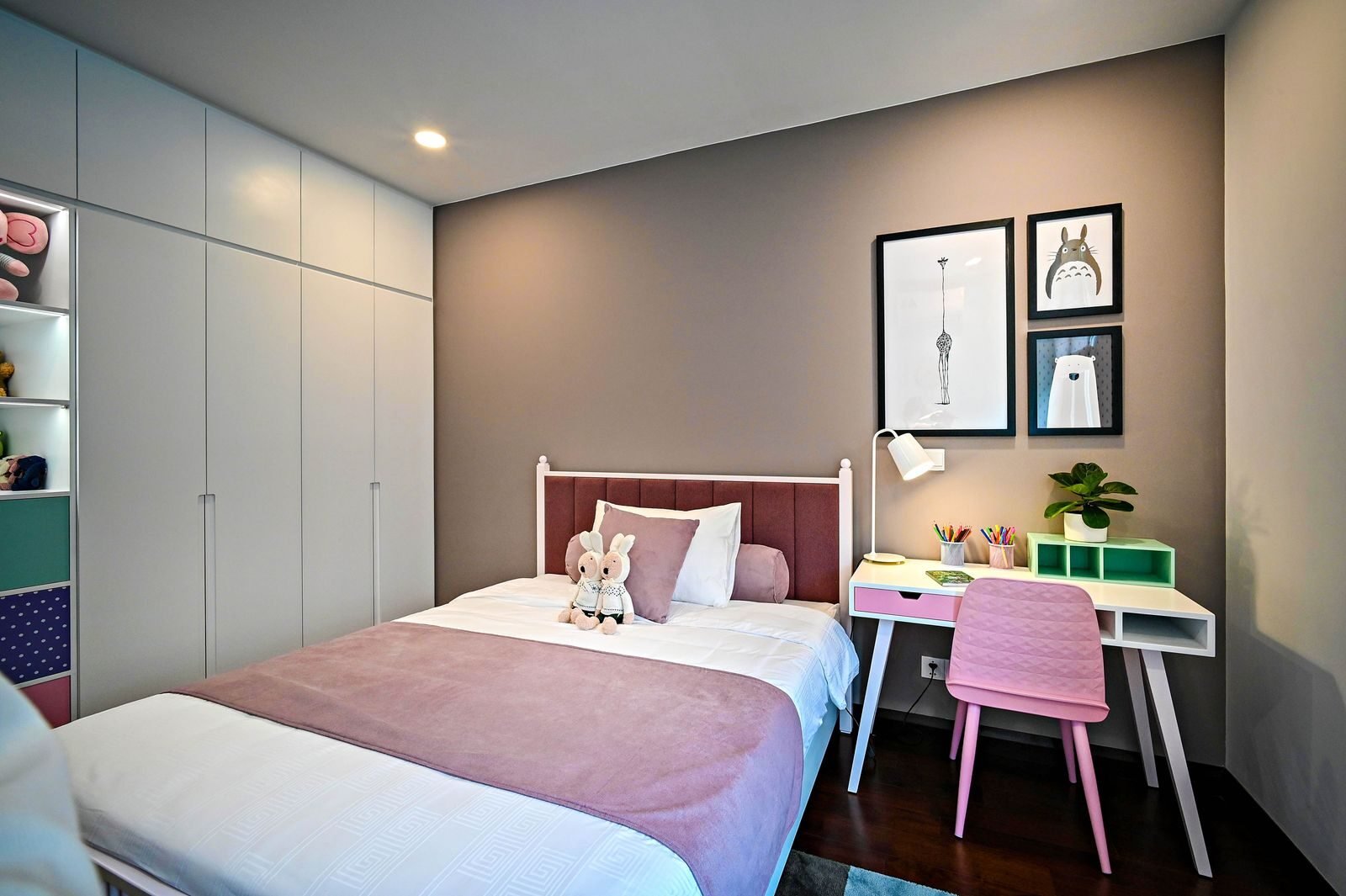 Child bedroom with a low bed, a study desk under the window and open storage at a height a child can reach