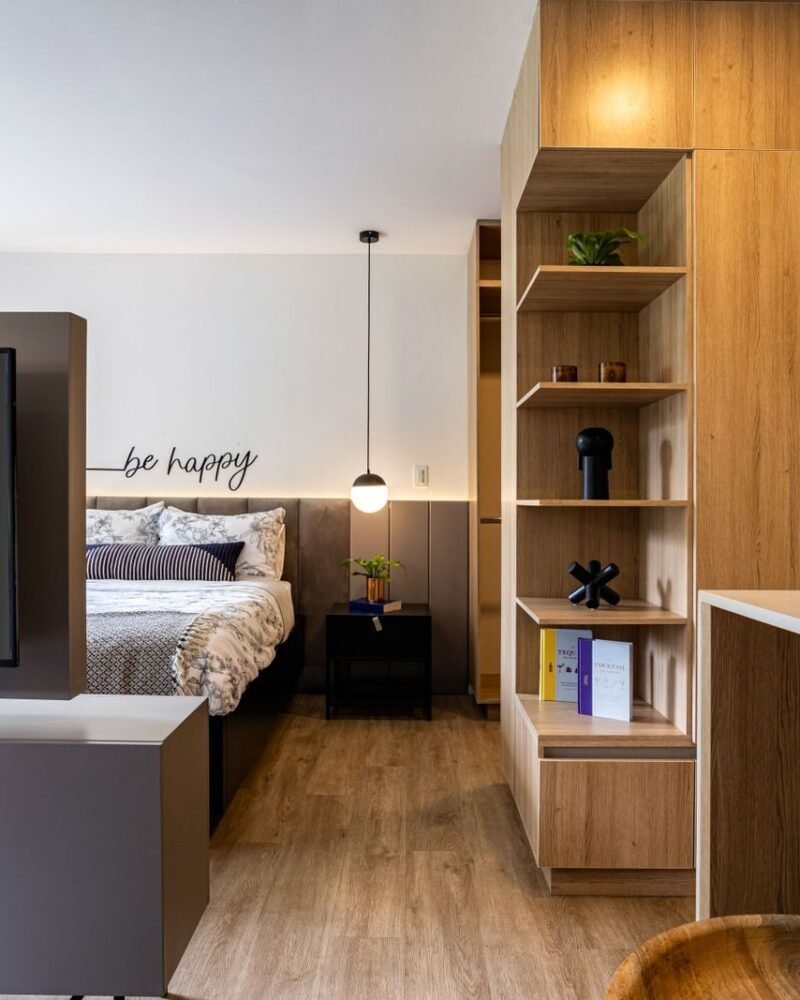 Small studio apartment zoned into sleeping and sitting areas using wooden furniture rather than partitions
